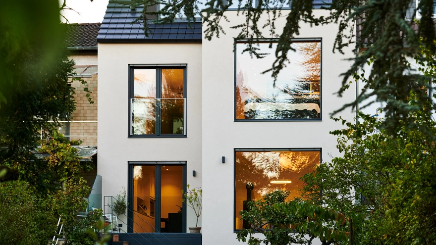 Sanierte Hausfassade mit großen Schüco Fenstern und Blick ins Grüne