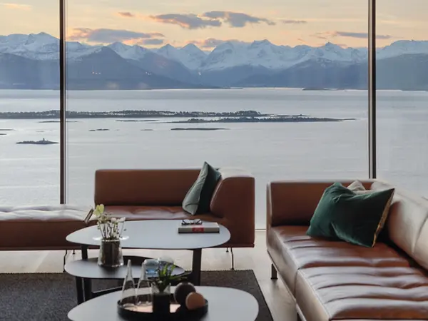 Wohnzimmer mit großer Fensterfront und Seeblick