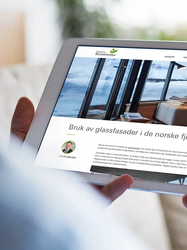 en person holder et nettbrett med Schüco Knowledge-nettstedtet på