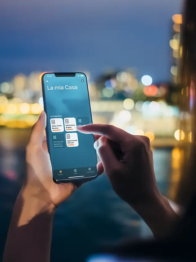rsona che controlla l'app Smart Home Schüco per gestire la casa intelligente