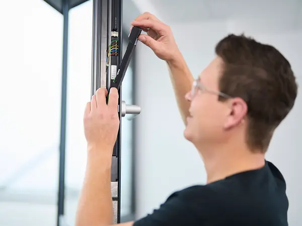 Tecnico Schüco che effettua retrofit di serramenti in alluminio per migliorare efficienza e sicurezza