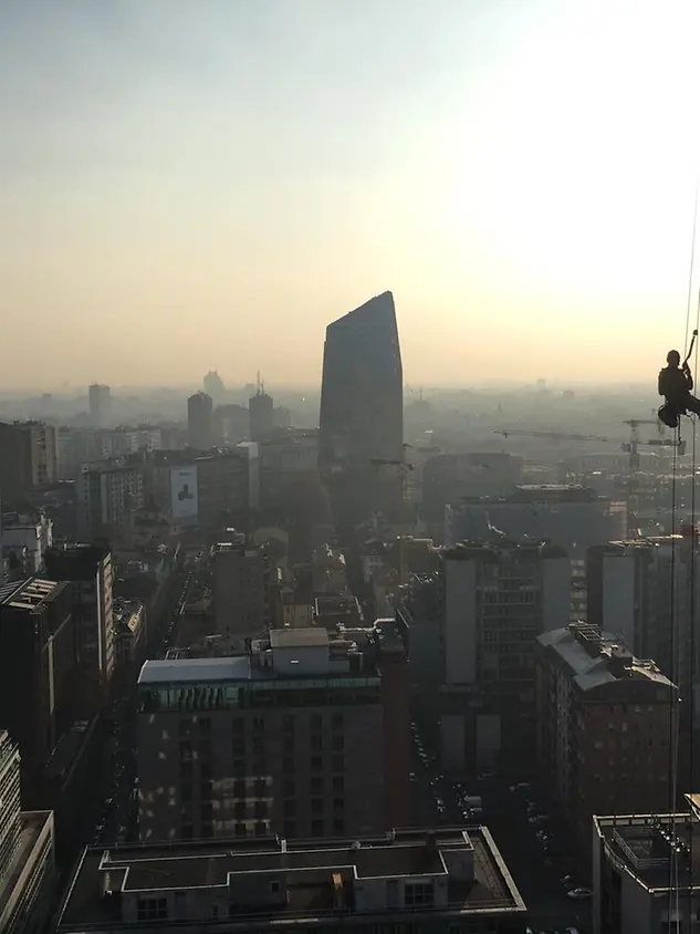 Tecnico Schüco in quota durante la manutenzione di una facciata in alluminio di un edificio commerciale