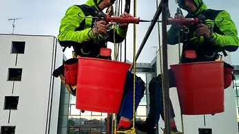 Tecnici 2High impegnati nel ripristino di una facciata in quota su edificio commerciale