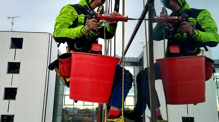 Tecnici 2High impegnati nel ripristino di una facciata in quota su edificio commerciale