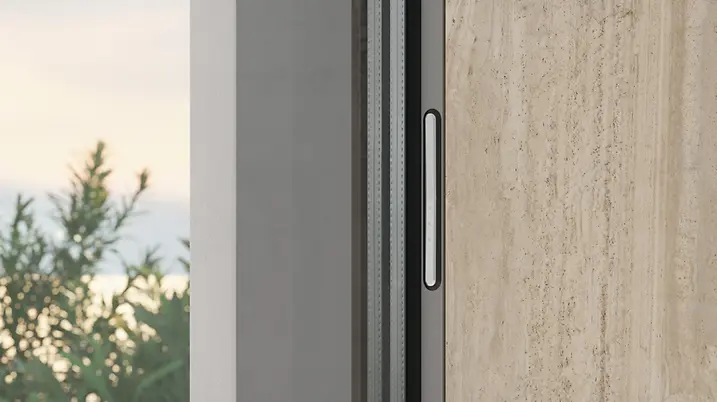 Dettaglio del sistema di movimentazione Schüco integrato nel profilo del serramento per apertura fluida