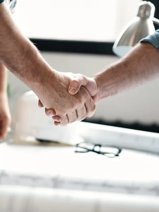 Cliente che stringe la mano a un serramentista Schüco Premium Partner dopo la consulenza