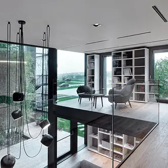 Spazio lounge di Theatro con poltrone, grandi vetrate e vista sull’esterno, pensato per incontri