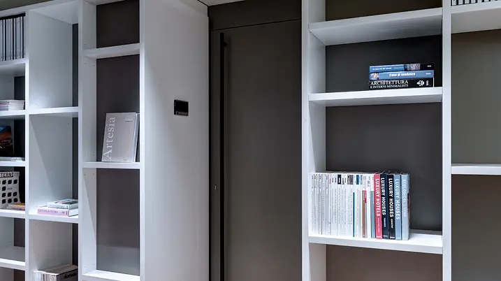 Dettaglio della libreria espositiva di Theatro con scaffali bianchi dedicati a materiali tecnici e pubblicazioni