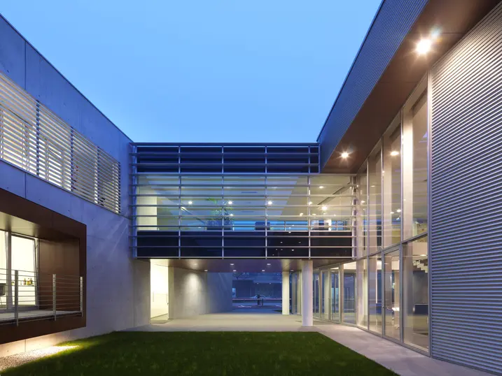 Cortile interno della sede Schüco Italia con passerelle e grandi superfici vetrate che collegano gli spazi uffici.