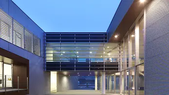 Cortile interno della sede Schüco Italia con passerelle e grandi superfici vetrate che collegano gli spazi uffici.