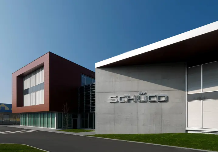Ingresso principale della sede Schüco Italia, con ampia facciata vetrata e volume degli uffici