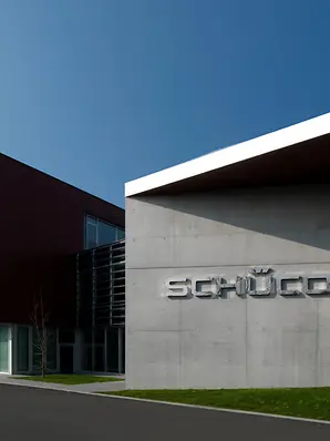 Ingresso principale della sede Schüco Italia, con ampia facciata vetrata e volume degli uffici