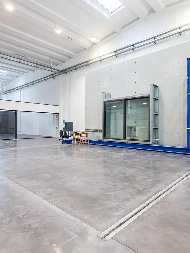 Vista del laboratorio prove Schüco Italia con banco di test e parete in cemento armato