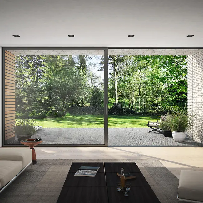 Ampia finestra scorrevole Schüco con vista sul verde, simbolo di prodotti sostenibili e ad alta efficienza energetica.