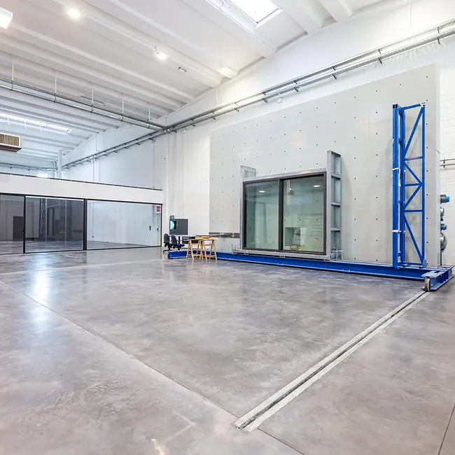 Vista del laboratorio prove Schüco Italia con banco di test e parete in cemento armato