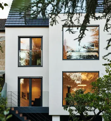 Modernisiertes Wohnhaus mit großen Schüco Fenstern in begrünter Umgebung