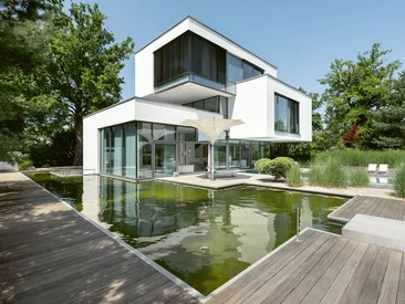 Moderne Wohnarchitektur mit großflächigen Schüco Fenstern, Gartenteich und fließendem Übergang zum Außenbereich