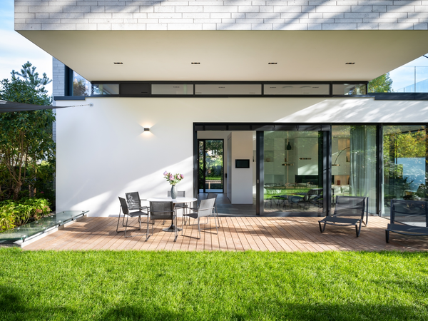 Modernes Wohnhaus mit Schüco Schiebesystem, Terrasse und grünem Garten