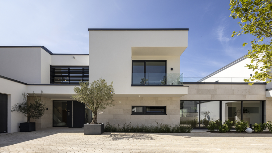 Moderne Wohnarchitektur mit großflächigen Schüco Fenstern und Schiebesystemen und moderner Haustür