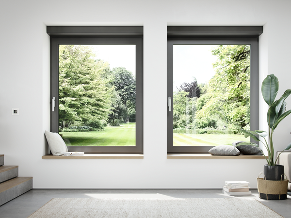Schüco Fenster mit integrierter Lüftung und Ausblick auf eine grüne Gartenlandschaft